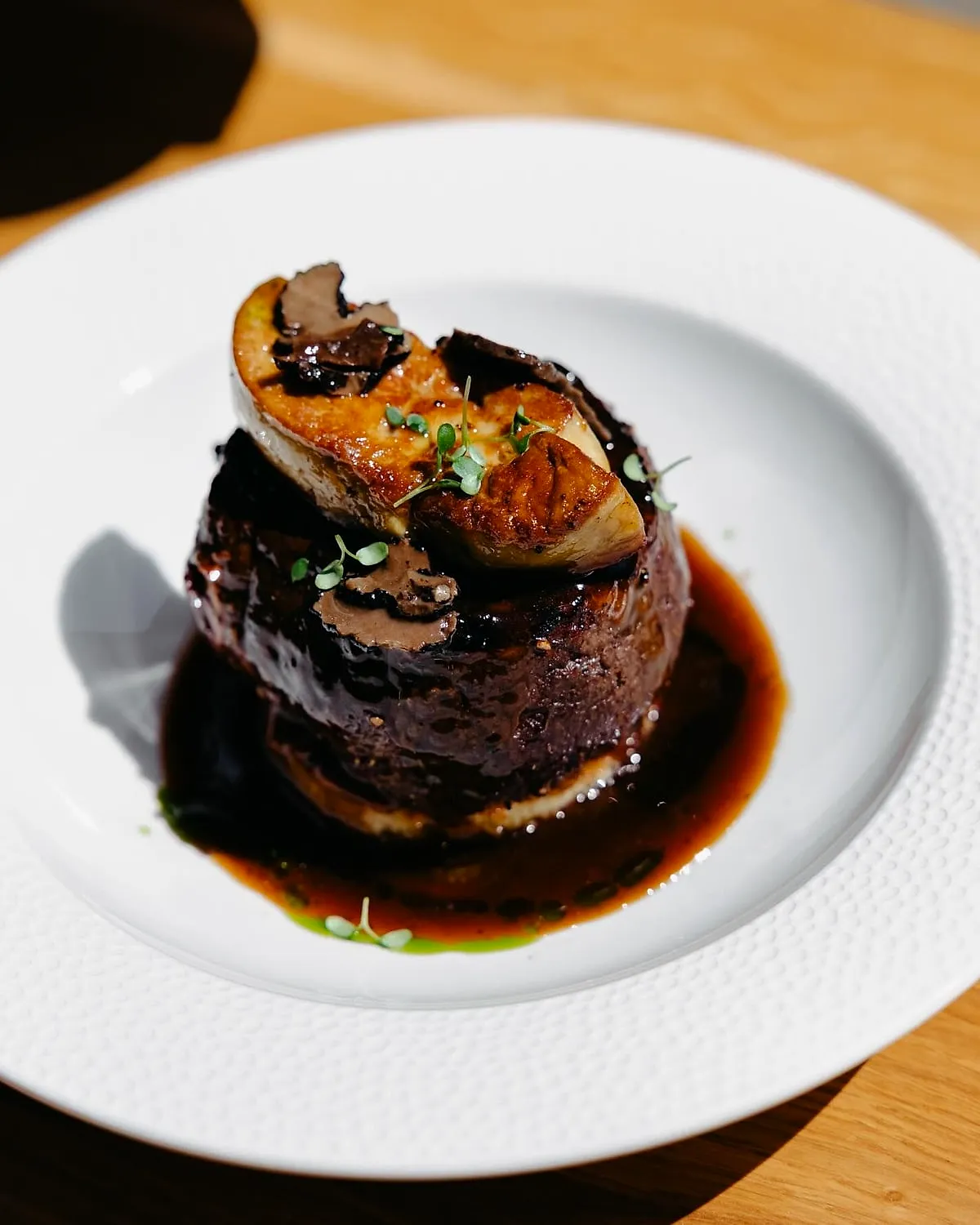 Filet Rossini cu foie gras pe farfurie albă